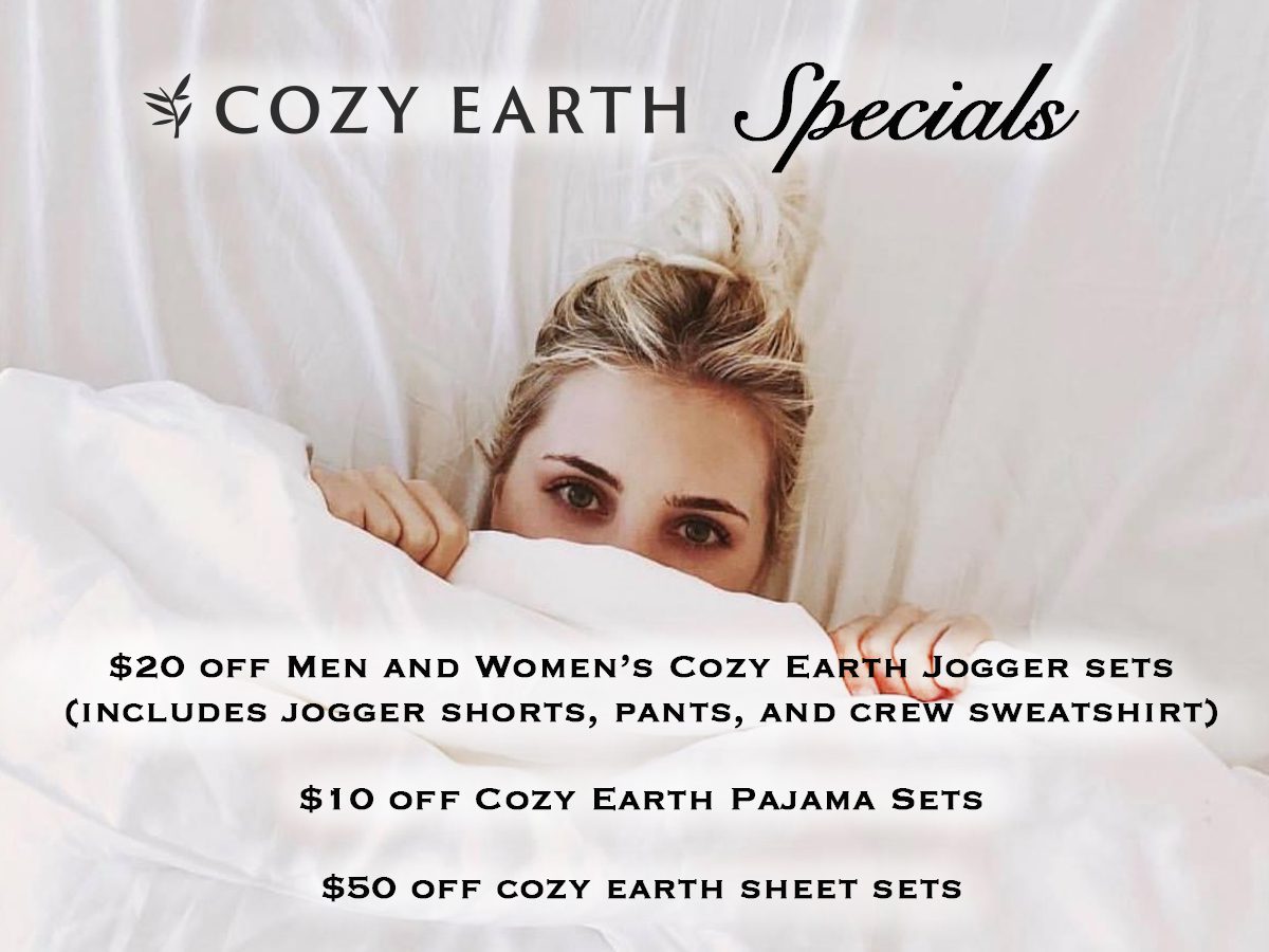 A woman peeking out from under the covers of her bed.