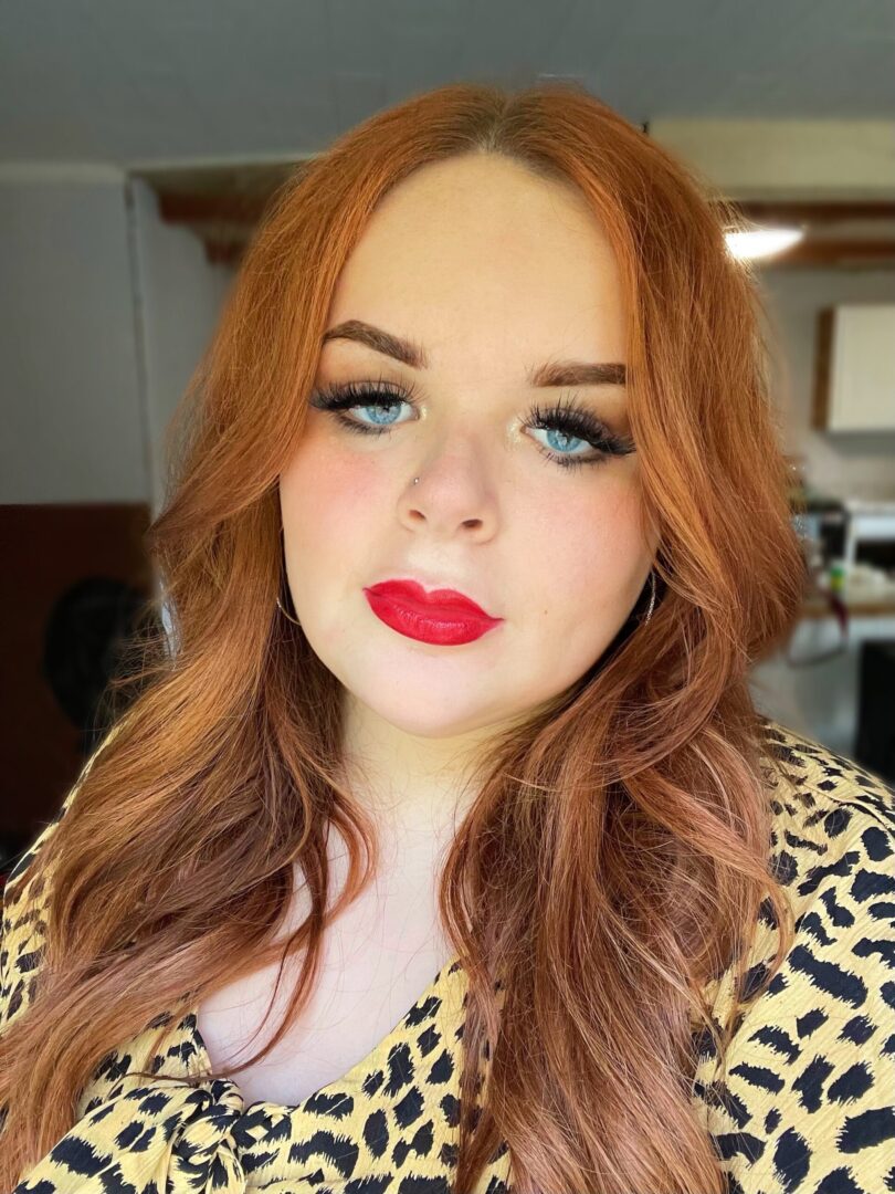 A woman with red hair and blue eyes.
